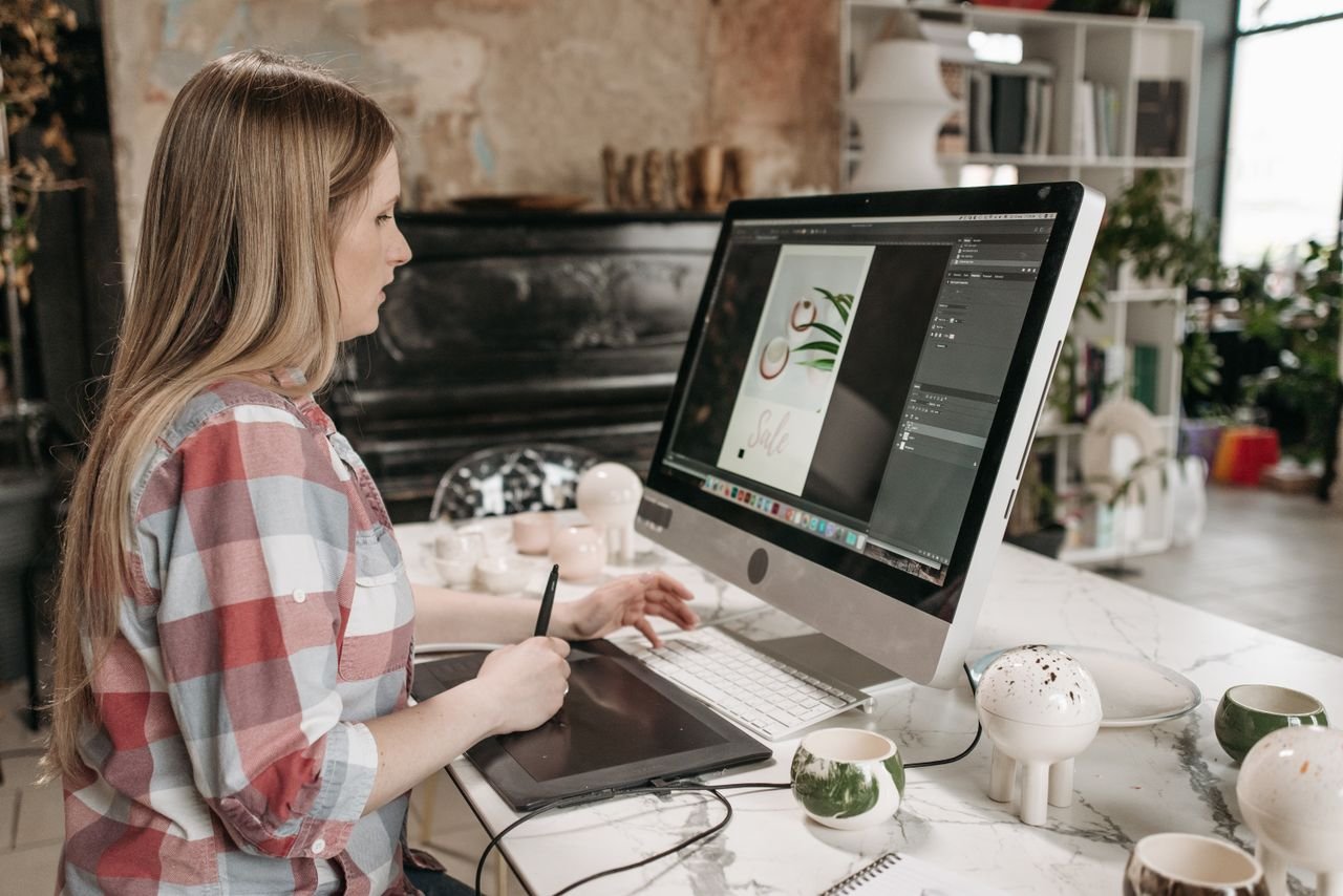 team-03 Woman using a digital drawing tablet in a stylish office workspace, focused on graphic design.