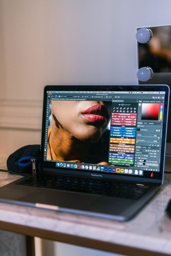 who-we-are A laptop displaying a graphic design software interface in a creative workspace.