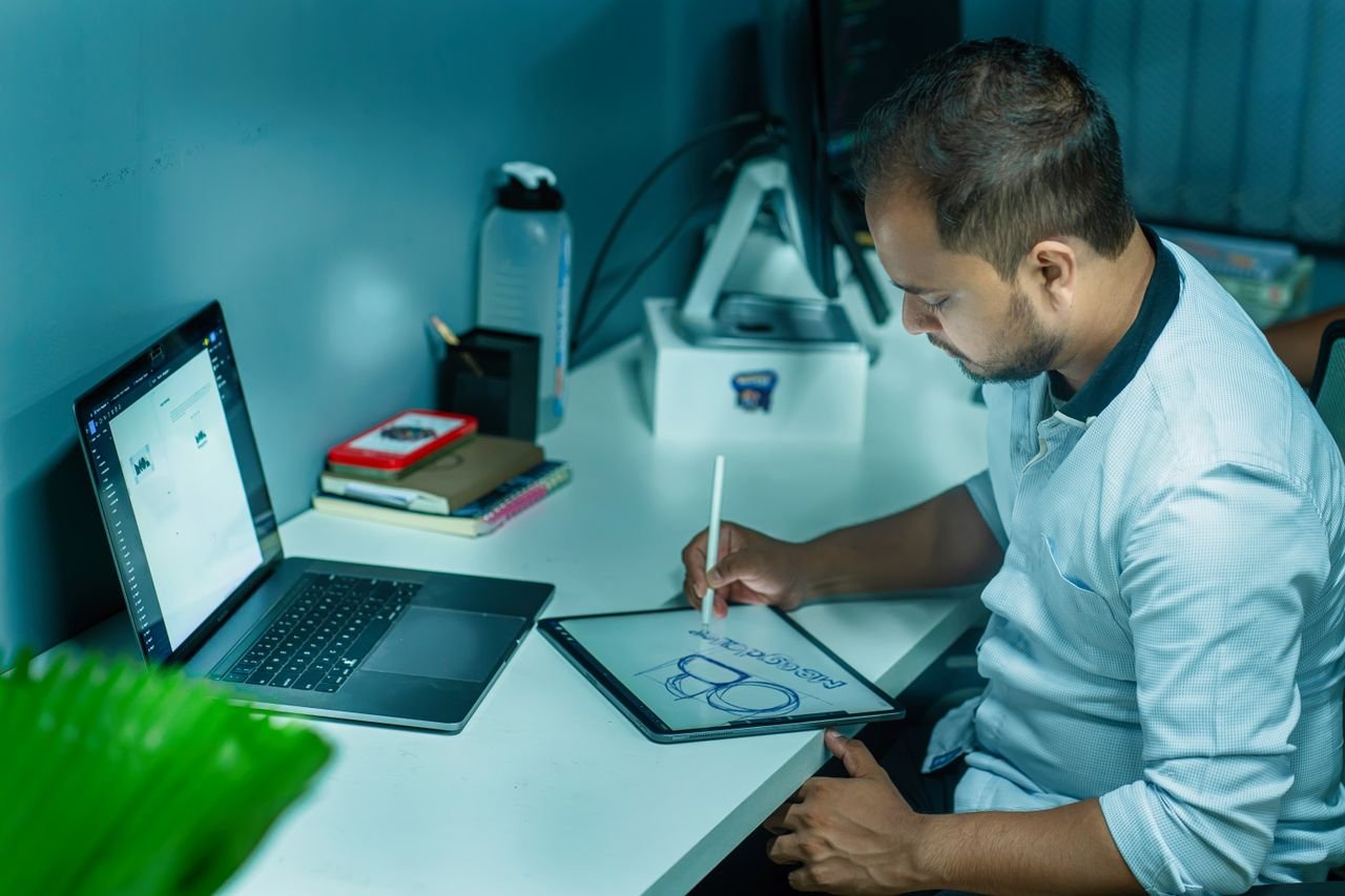 Crafting Captivating Headlines: Your awesome post title goes here A focused man uses a tablet to design while working at his desk in a modern office setting.